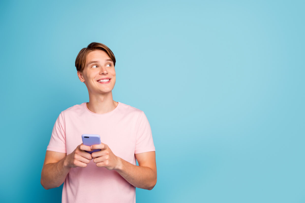 Porträt eines fröhlichen Mannes, der mit seinem Smartphone in den sozialen Medien chattet